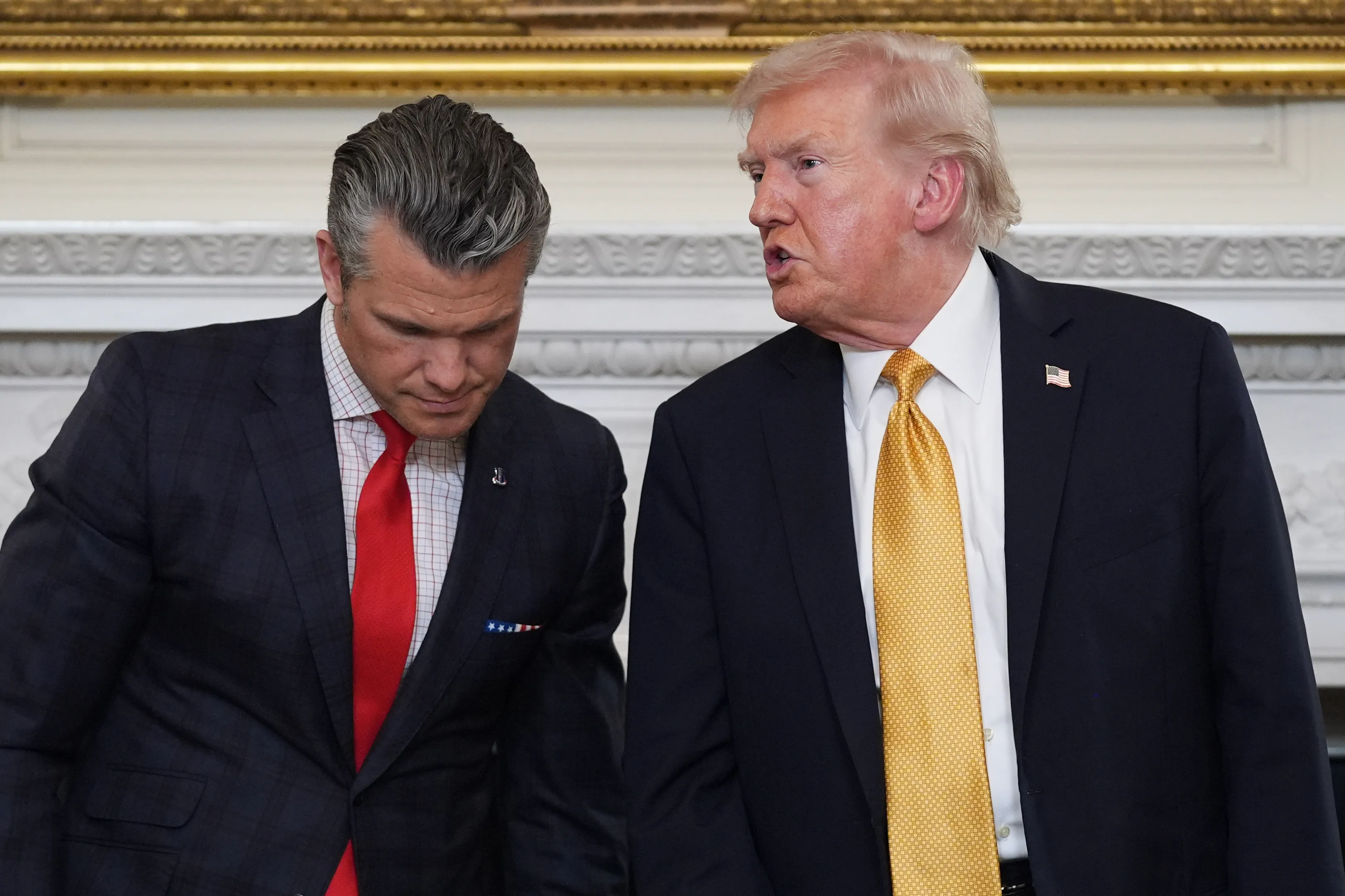 President Donald Trump talks with Defense Secretary Pete Hegseth