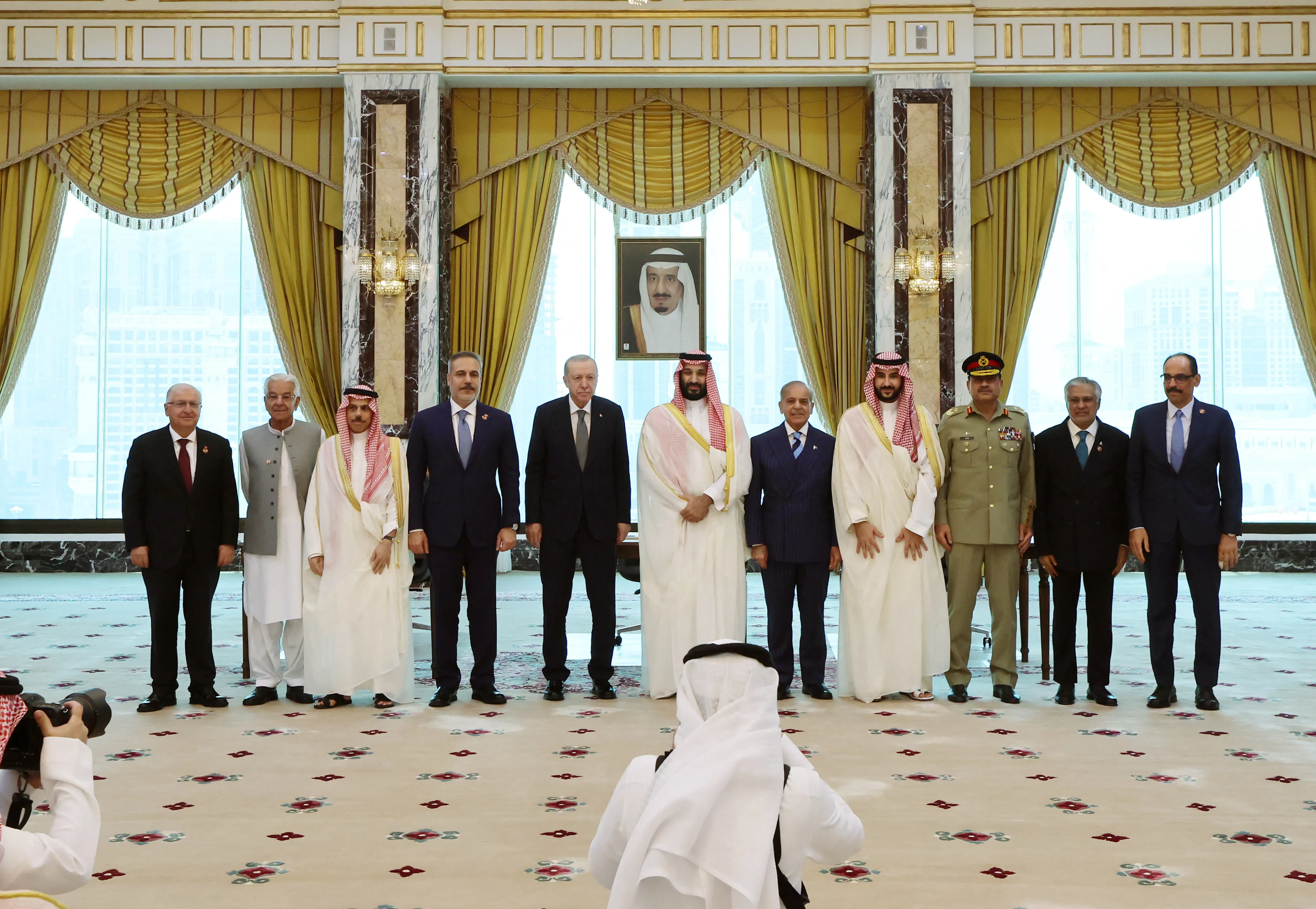 This handout photograph taken and released by Turkish Presidency Press Office on August 7, 2026, shows Minister of Foreign Affairs of Saudi Arabia Prince Faisal bin Farhan al-Saud (3rd L), Turkish Foreign Minister Hakan Fidan (4th L), Turkish President Recep Tayyip Erdogan (5th L), Saudi Crown Prince Mohammed bin Salman (C), Pakistani Prime Minister Shehbaz Sharif (5th R), Saudi Defense Minister Prince Khalid bin Salman al-Saud (4th R), and their delegations as they pose after signing a trilateral joint defense agreement in Mecca, Saudi Arabia.