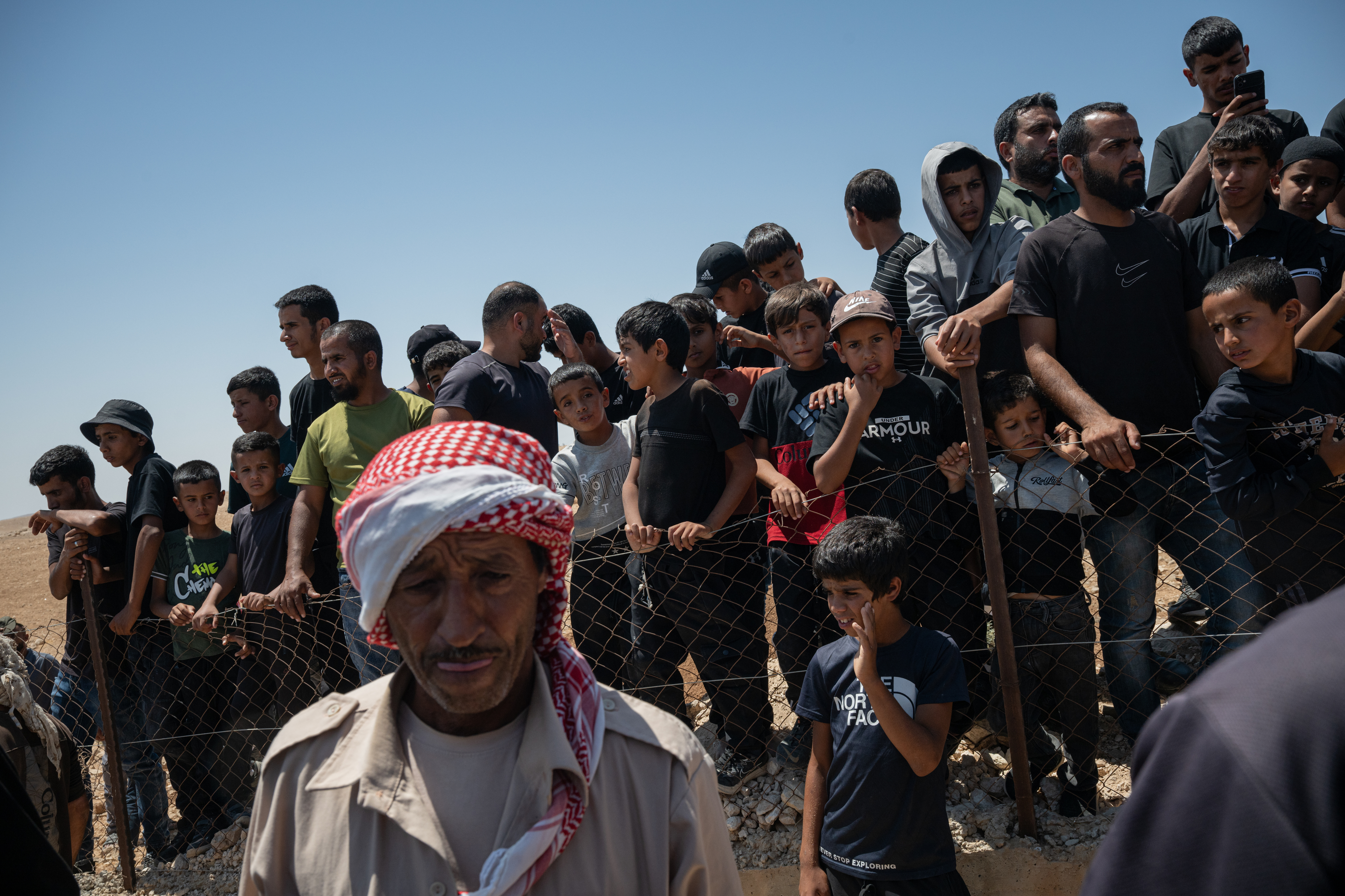 UMM AL-KHEIR, WEST BANK - AUGUST 7: Family and friends of Awdah Hathaleen look on as his body is buried during his funeral on August 7, 2025 in Umm al-Kheir, West Bank. The 31-year-old Palestinian activist and father of three was killed on July 28 when Israeli settler Yinon Levi allegedly opened fire during a confrontation in the Bedouin village of Umm al-Kheir (or Umm al-Khair), in the Masafer Yatta region of the occupied West Bank. A group of local women had gone on hunger strike to demand an unconditional release of Hathaleen's body, as well as the release of several people who were detained by Israeli forces following the shooting incident. Levi, who is sanctioned by the UK, EU, and previously by the US, was temporarily detained on house arrest following Hathaleen's death. Hathaleen was known for his work on the Oscar-winning film 'No Other Land,' which documents the Israeli demolition of Palestinian homes in Masafer Yatta. (Photo by Tamir Kalifa/Getty Images)